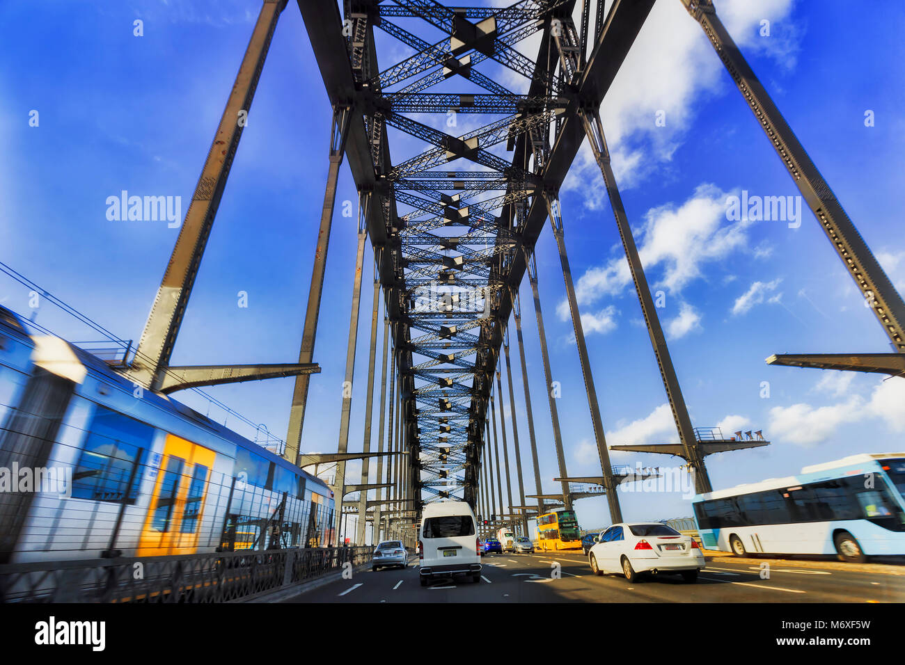 Public transportation and private passenger cars during intense traffic rush hour driving over Sydney harbour bridge in Sydney city CBD from Western D Stock Photo