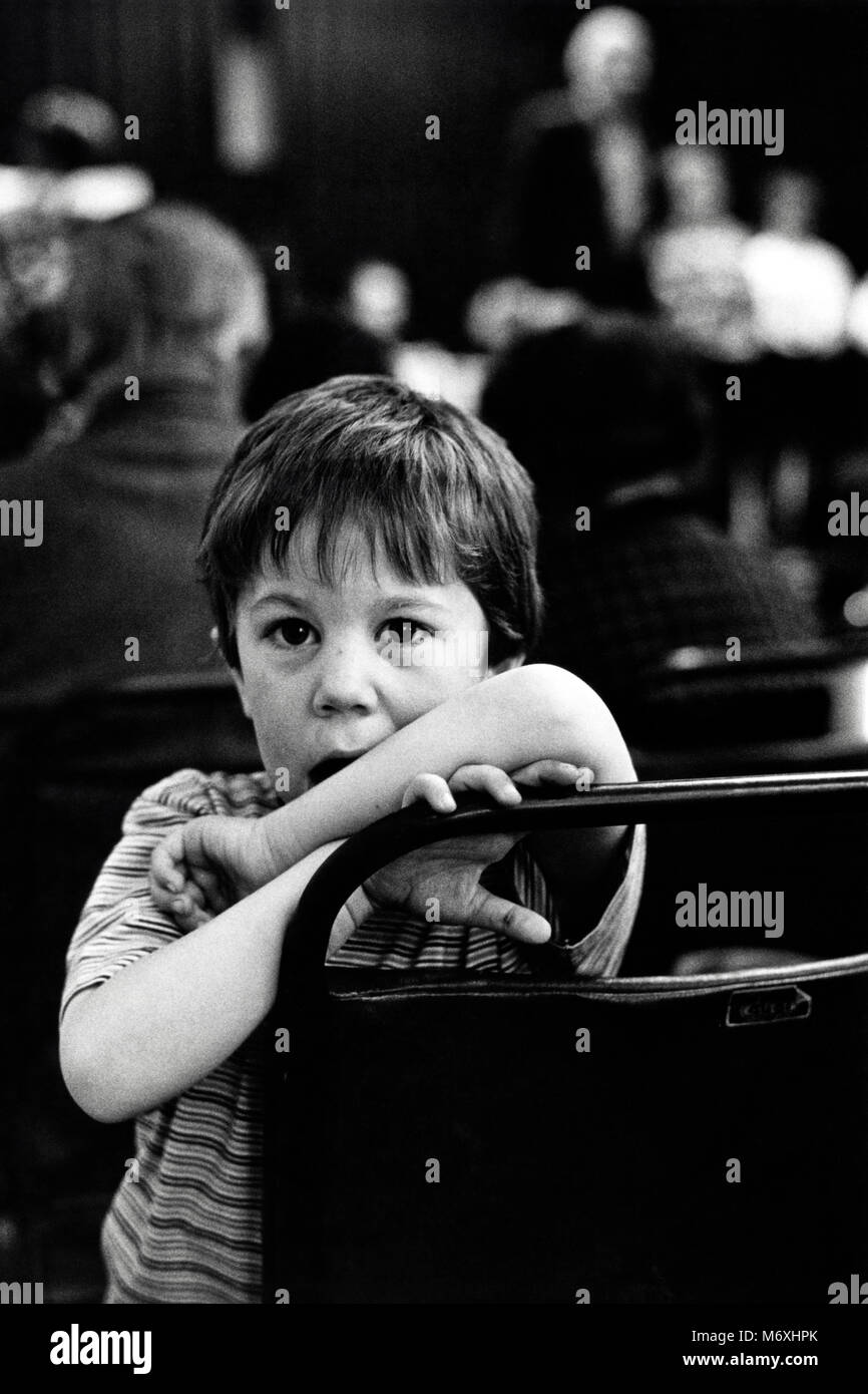 Boy posing in audience at small eisteddfod in village hall at Y Groeslon Gwynedd North Wales UK Stock Photo