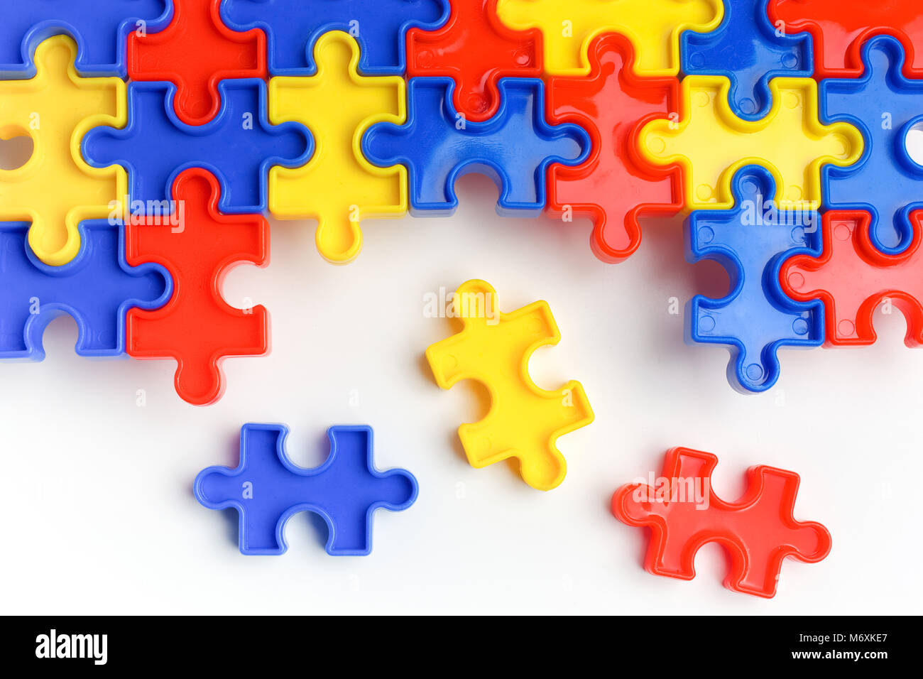 Pieces from a colorful jigsaw puzzle arranged to form a page on white background. Break barriers together for autism. Stock Photo