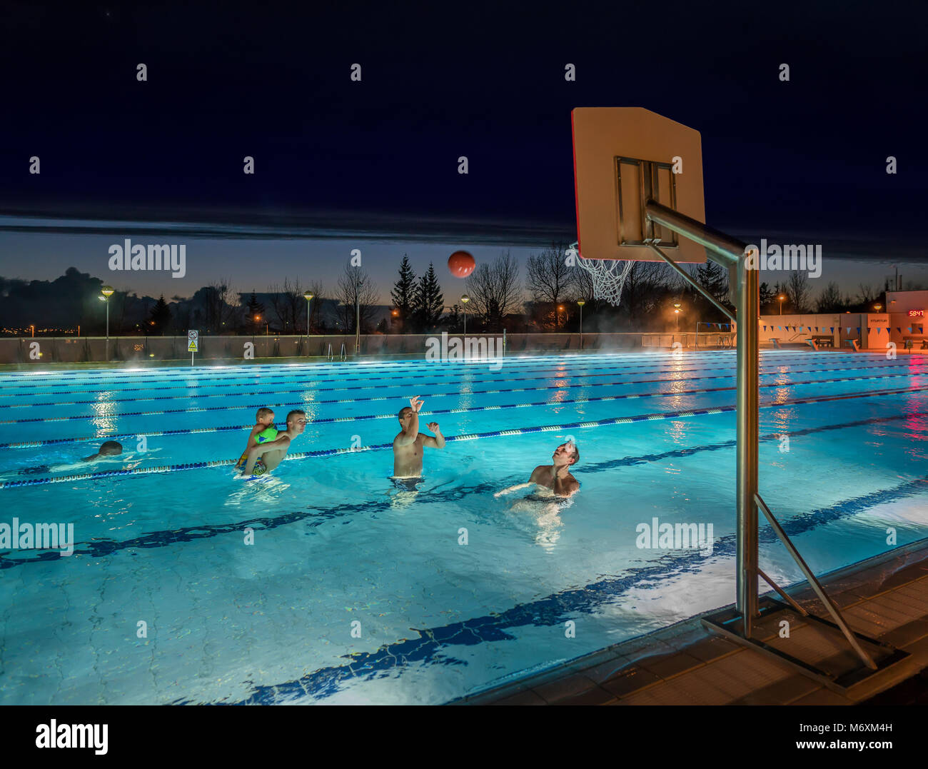 Playing basketball in a swimming pool, Iceland Stock Photo