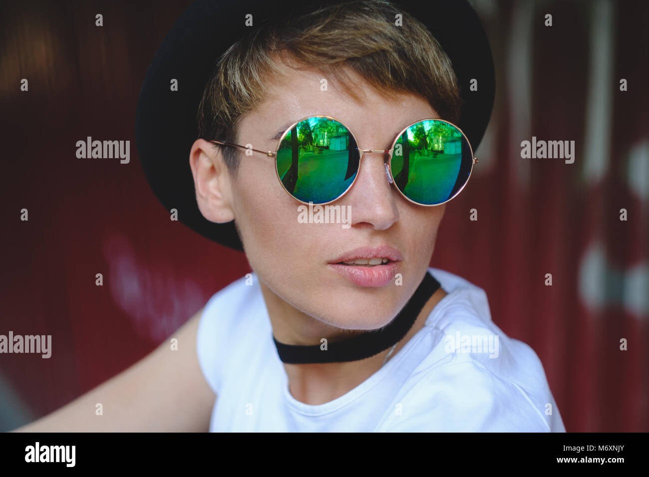 Young woman portrait wearing stylish hat and round glasses Stock Photo