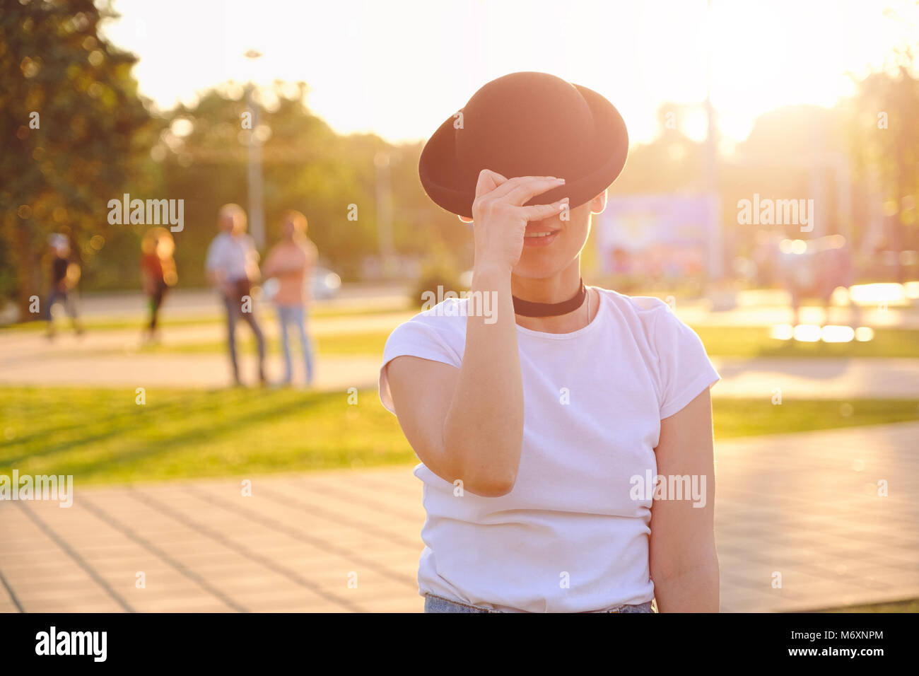 Beautiful woman hiding face behind hat showing eyes Stock Photo