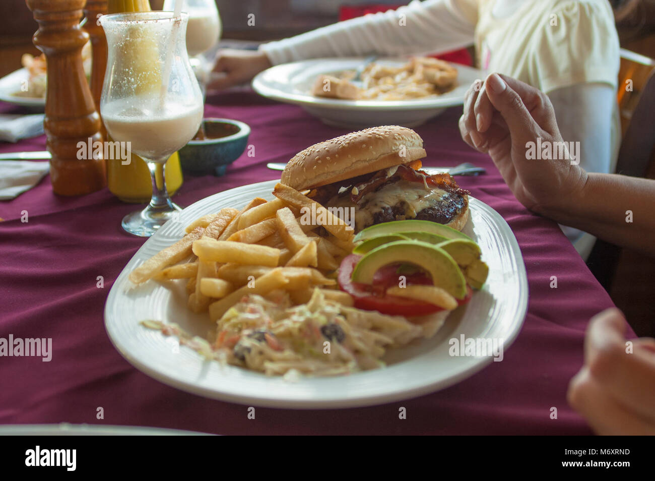hamburger with fries on table as part of family dinner in a restaurant Stock Photo