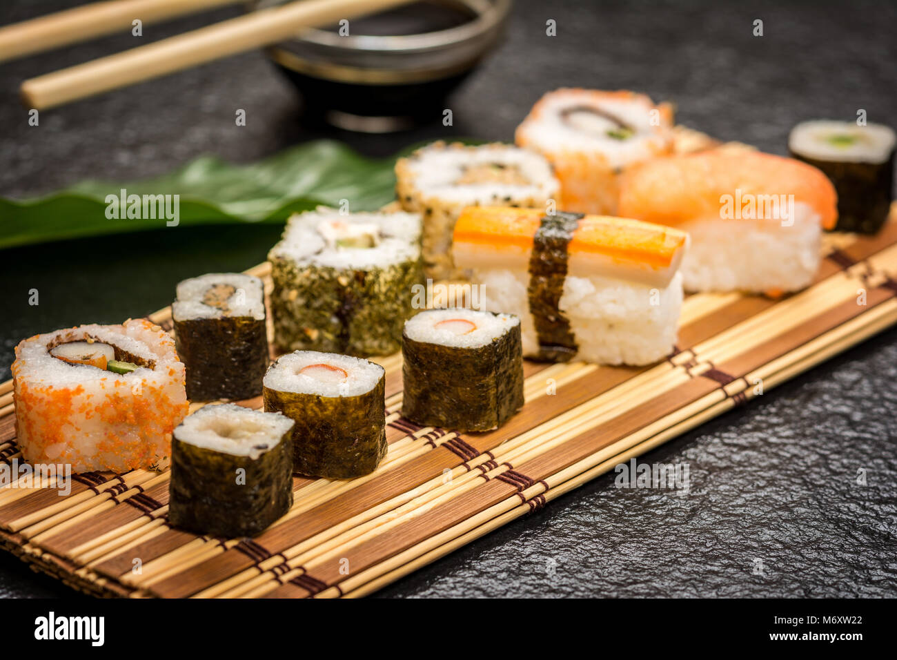 Traditional japanese sushi rolls hosomaki,uramaki, nigiri  and chopsticks and soy sauce on stone desk Stock Photo