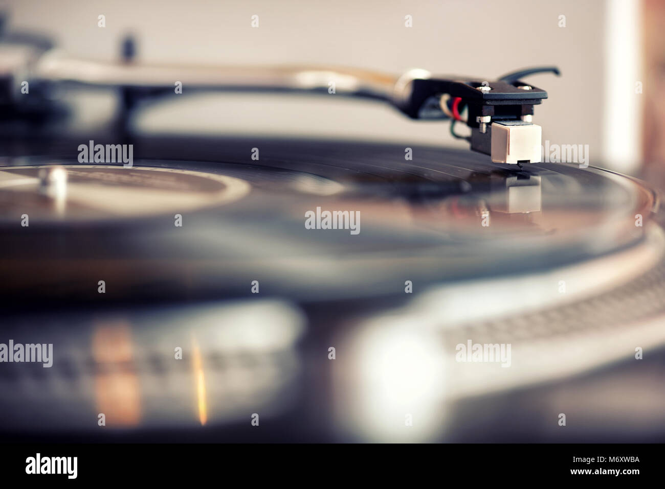 Low angle view of a needle on a retro vinyl gramophone record playing music indoors for personal entertainment Stock Photo