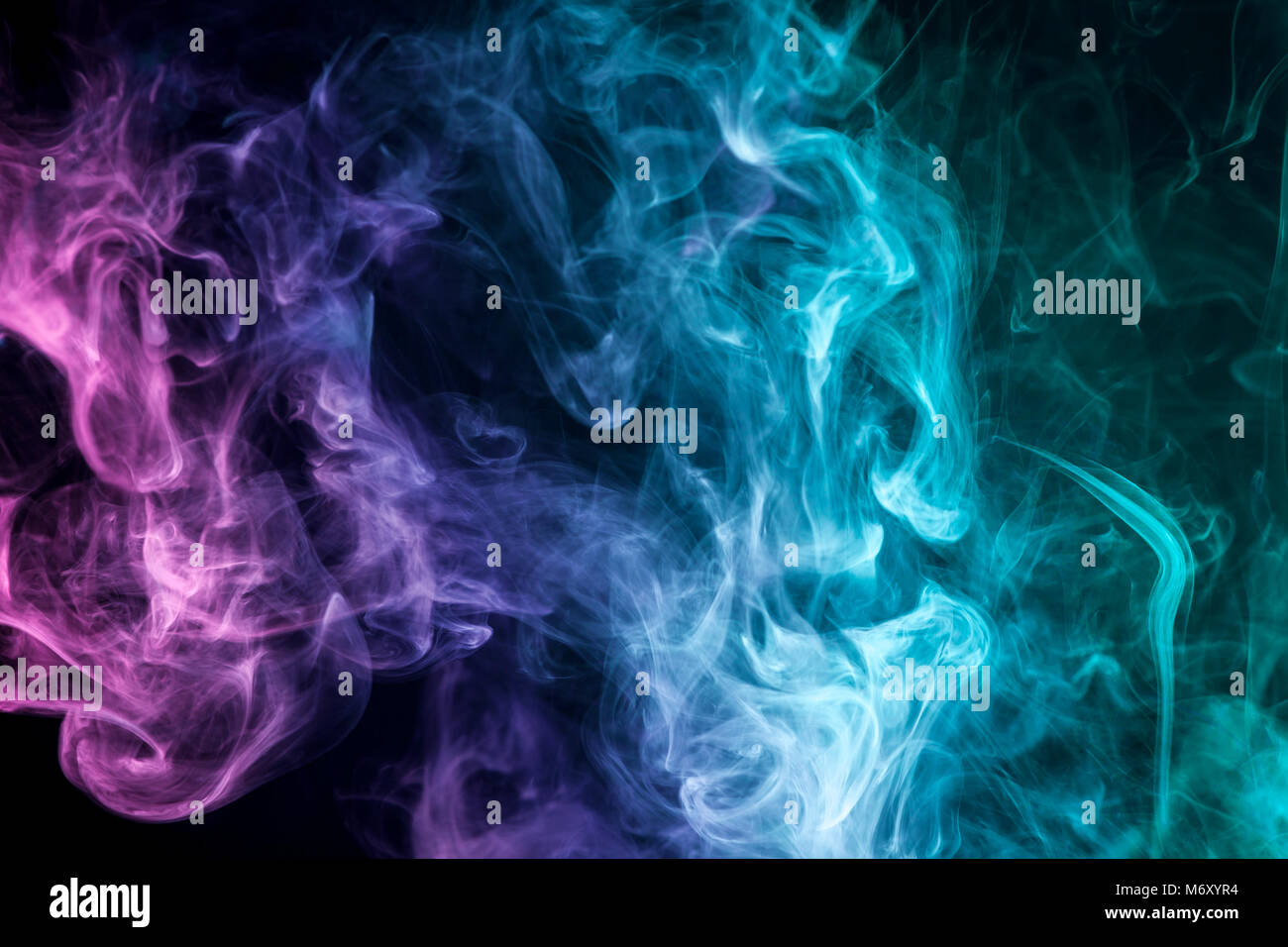 Thick colorful smoke of blue, purple on a black isolated background.  Background from the smoke of vape Stock Photo