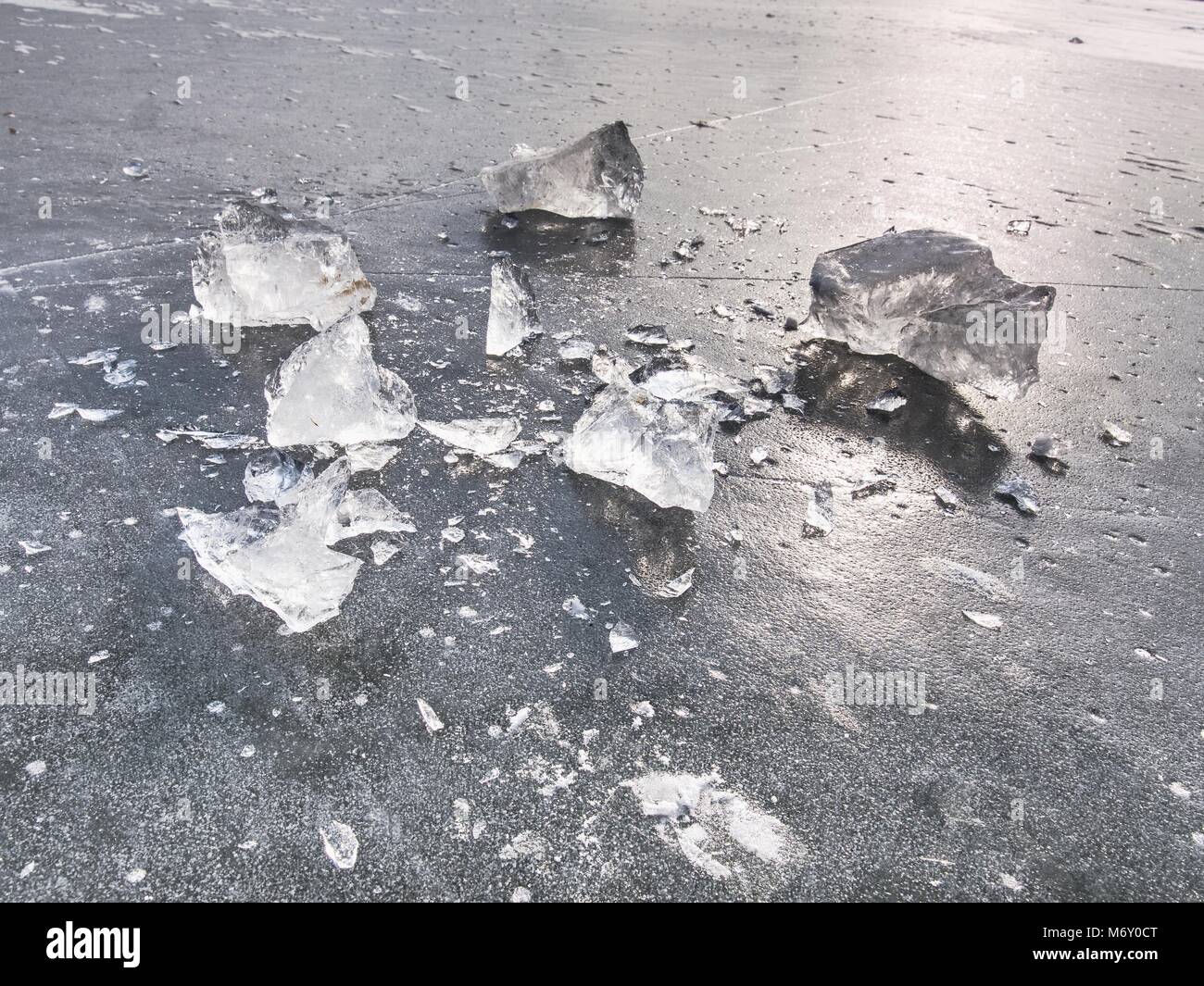 Shining shards of broken ice. Abstract still life of ice floes on lavel of frozen lake. Stock Photo