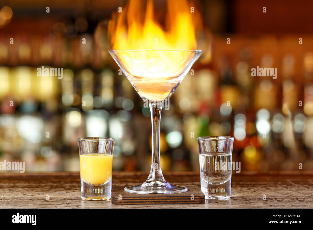 Club cocktail with fire in a bar on a blurry background of alcohol