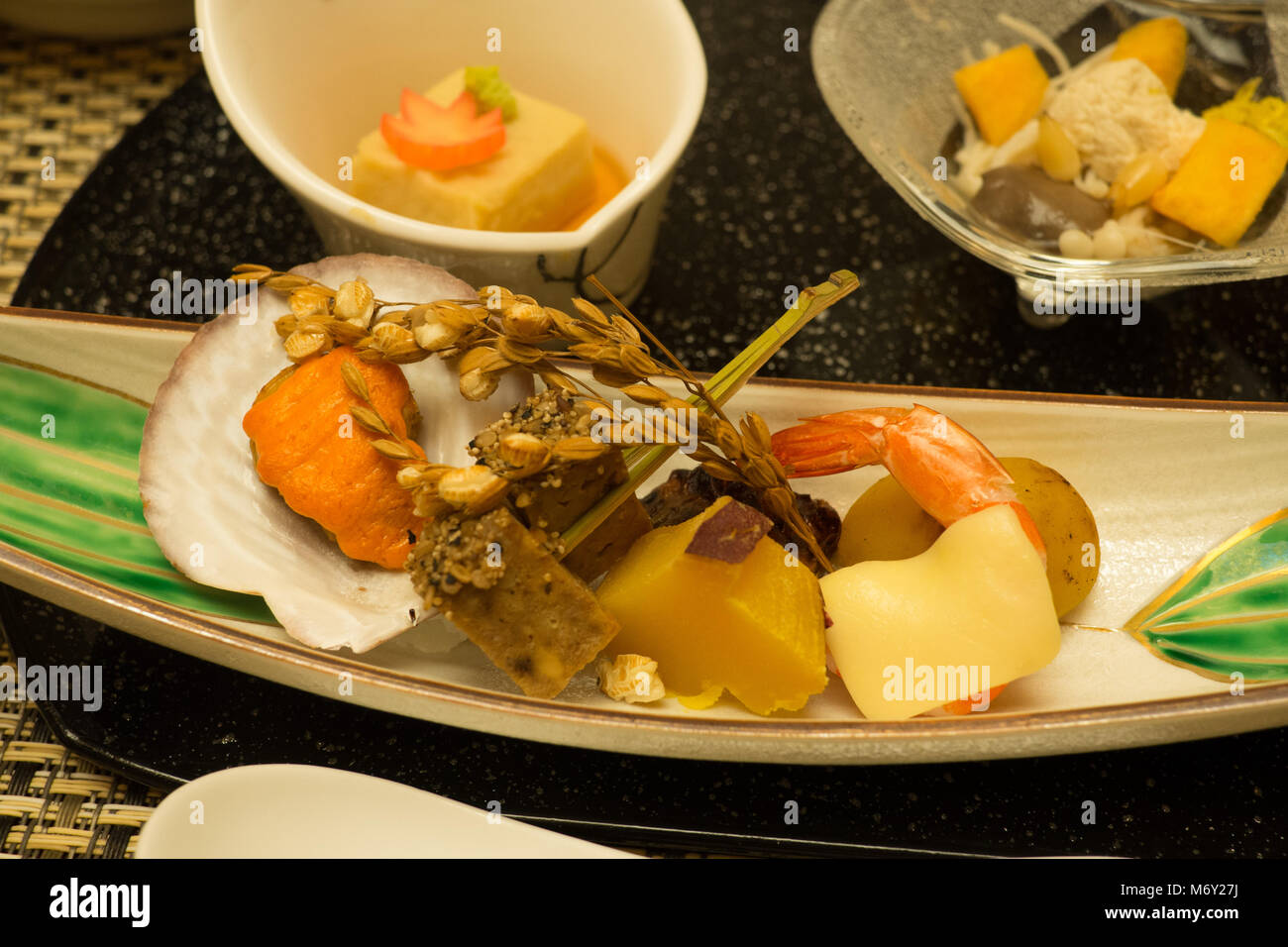 Assortment of seafood served which includes a clam, prawn, pickled