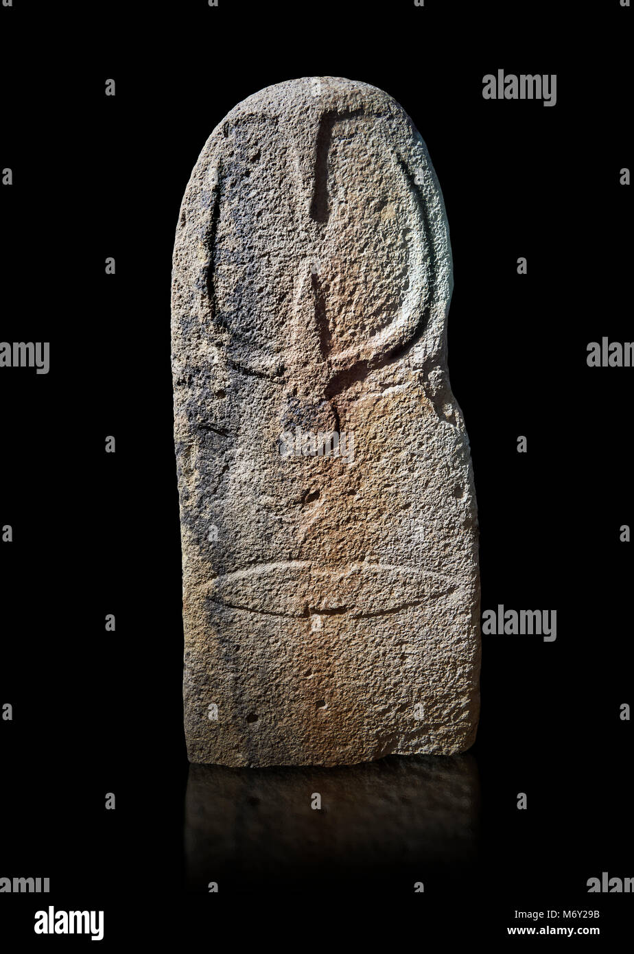 Late European Neolithic prehistoric Menhir standing stone with carvings on its face side. The representation of a stylalised male figure starts at the Stock Photo