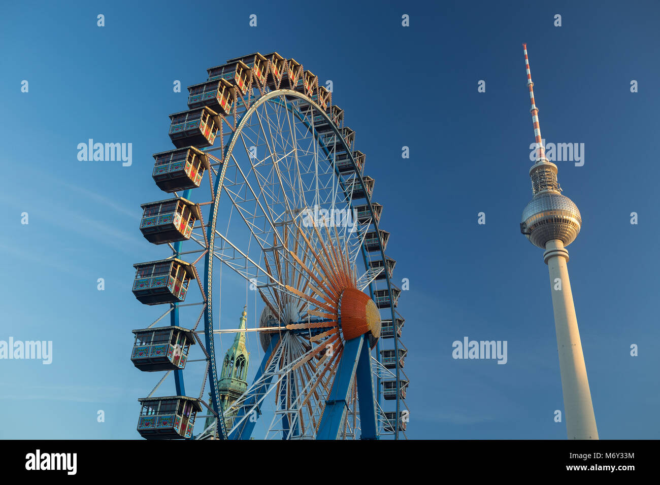 A ferris wheel at Neptunbrunnen with the Fernsehturm (TV Tower) in Alexanderplatz behind, Mitte, Berlin, Germany Stock Photo