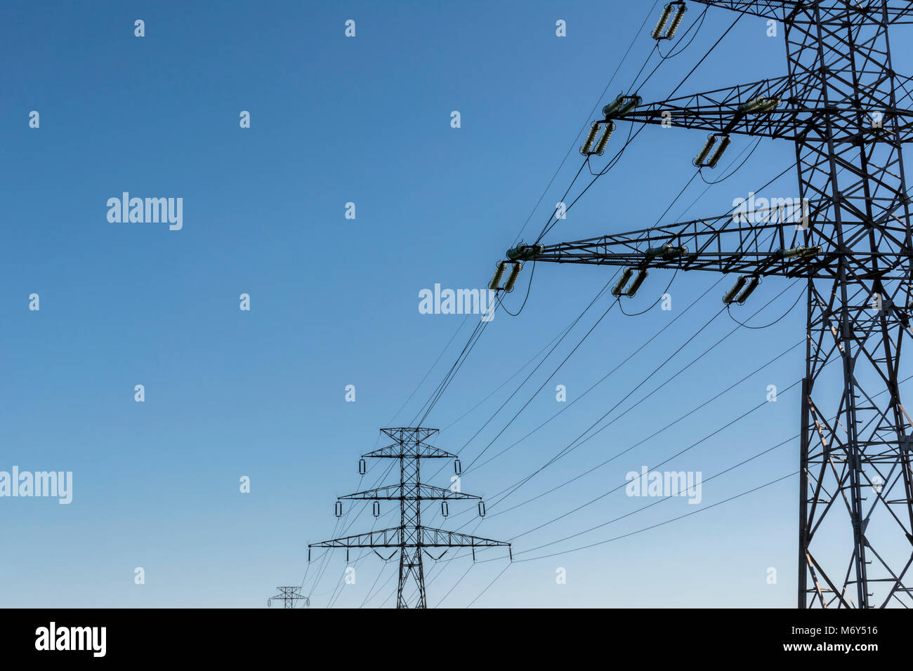 Electricity pillar high voltage line, blue sky Stock Photo - Alamy