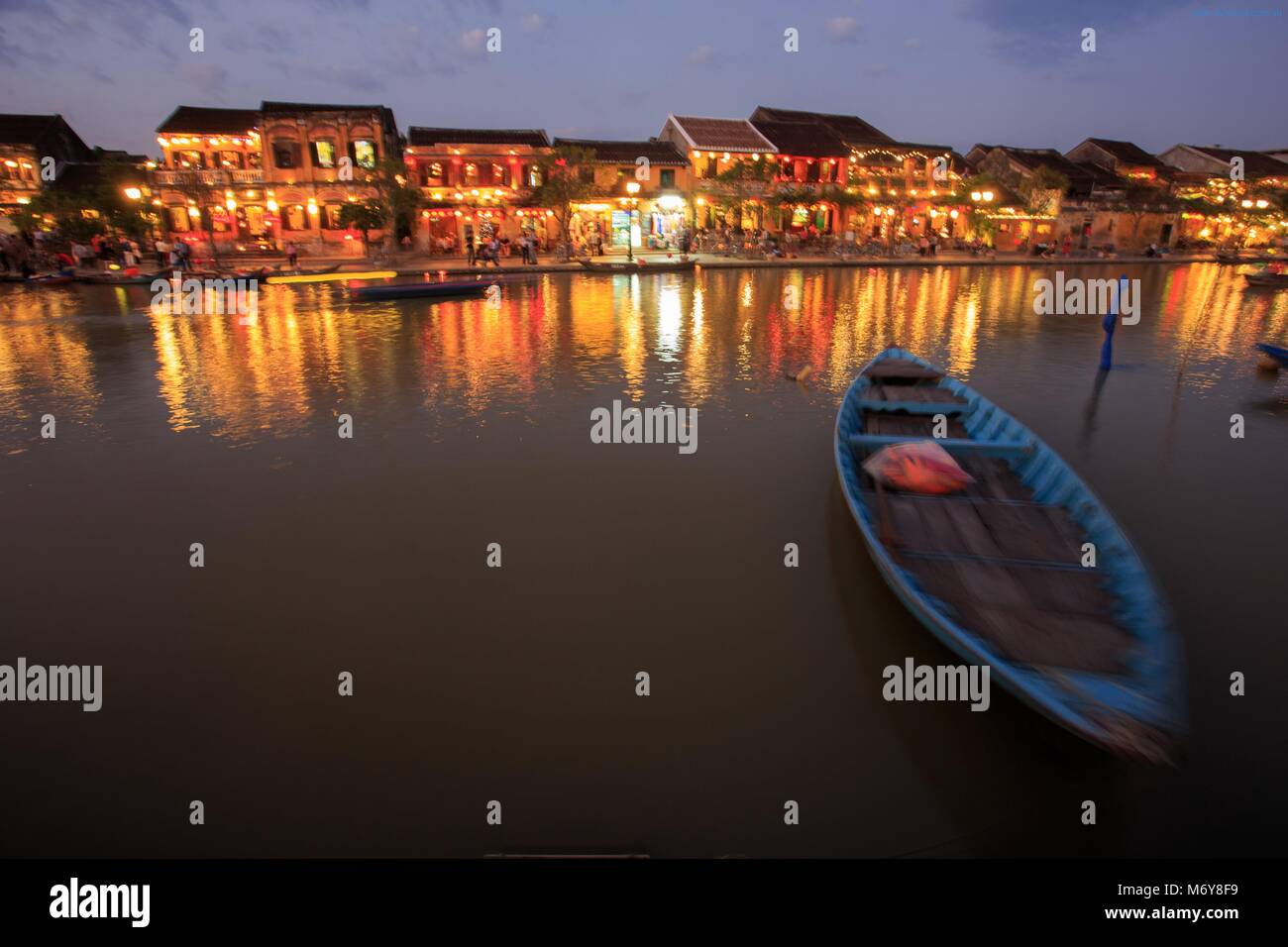 Wooden boats moored on the Thu Bon river opposite Bach Dang Street in the old town of Hoi An, Vietnam Stock Photo