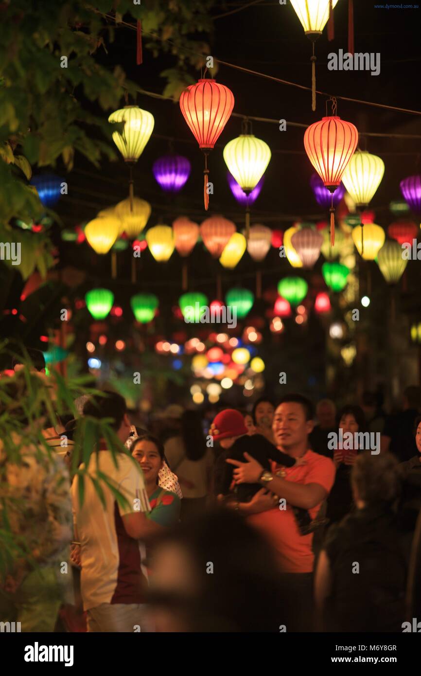 Tourists mix with locals under colourful lanterns in the old town of Hoi An, Vietnam Stock Photo