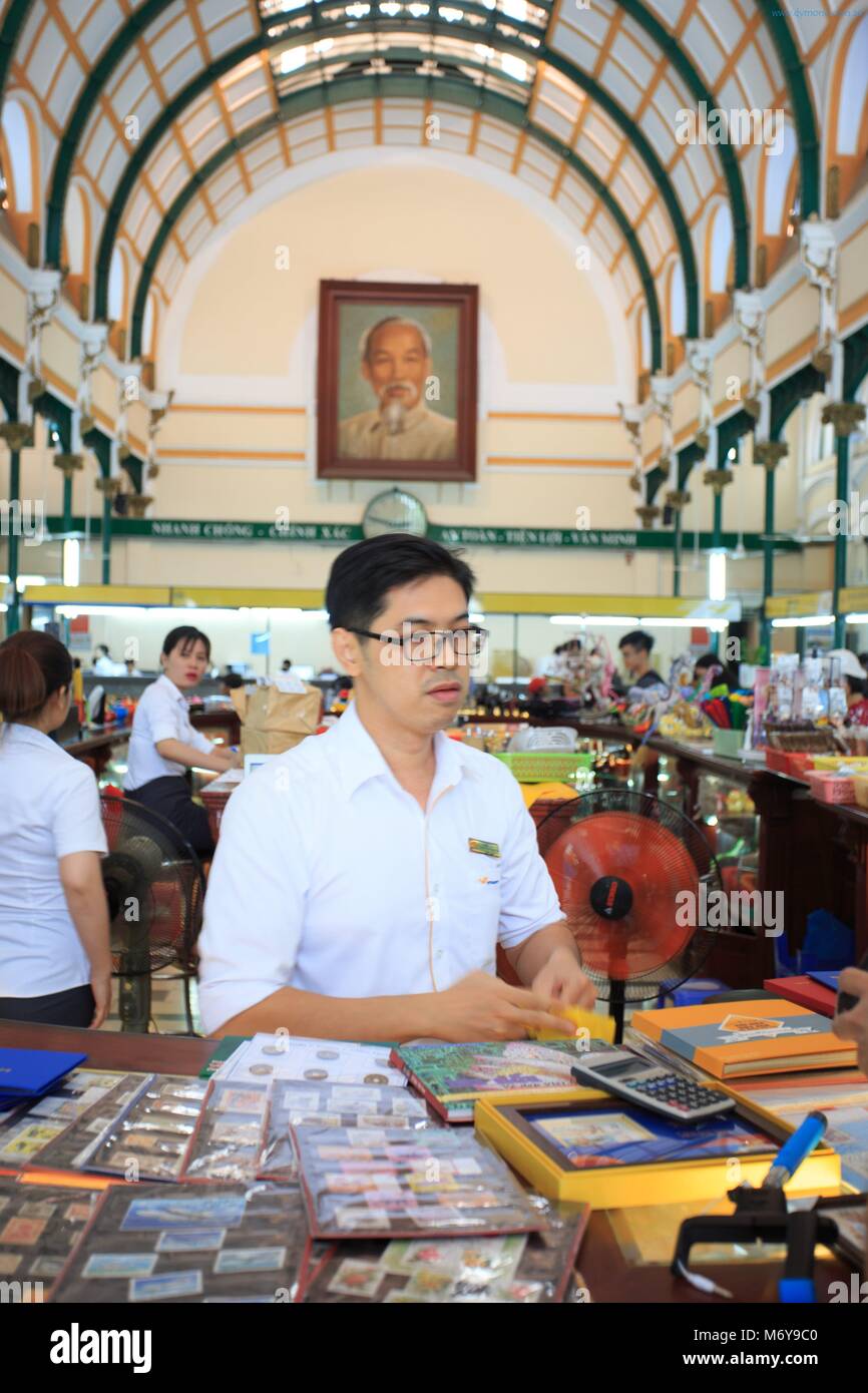 A post office worker serves a customer at the Central Post Office in Ho Chi Minh City, Vietnam Stock Photo