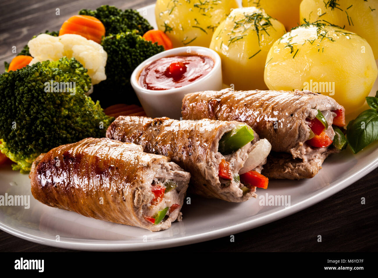 Wrapped pork chop, boiled potatoes and vegetables Stock Photo