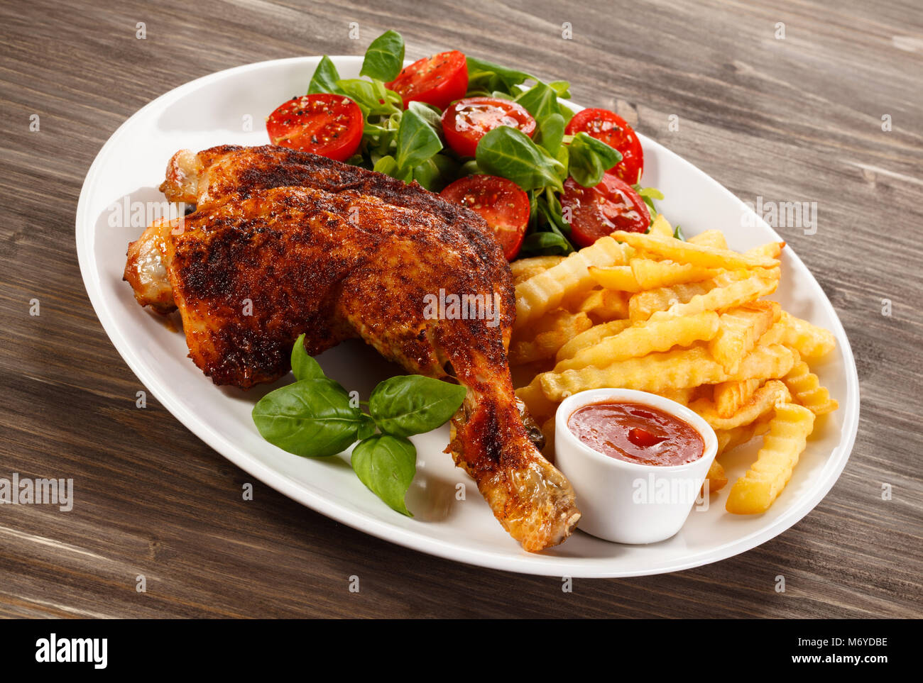 Roast chicken legs with french fries Stock Photo - Alamy