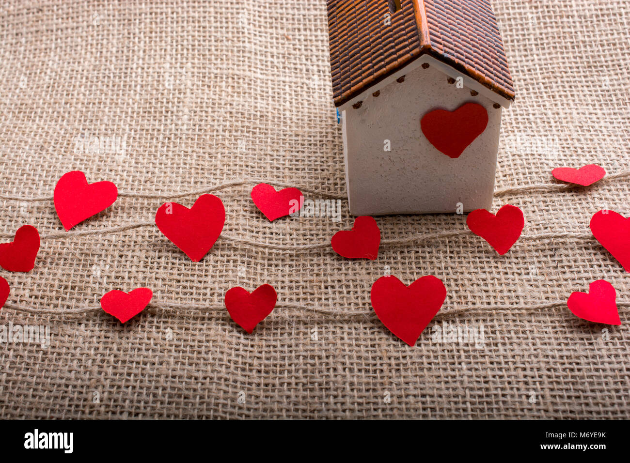 Heart shaped icons and paper house on linen threads Stock Photo - Alamy