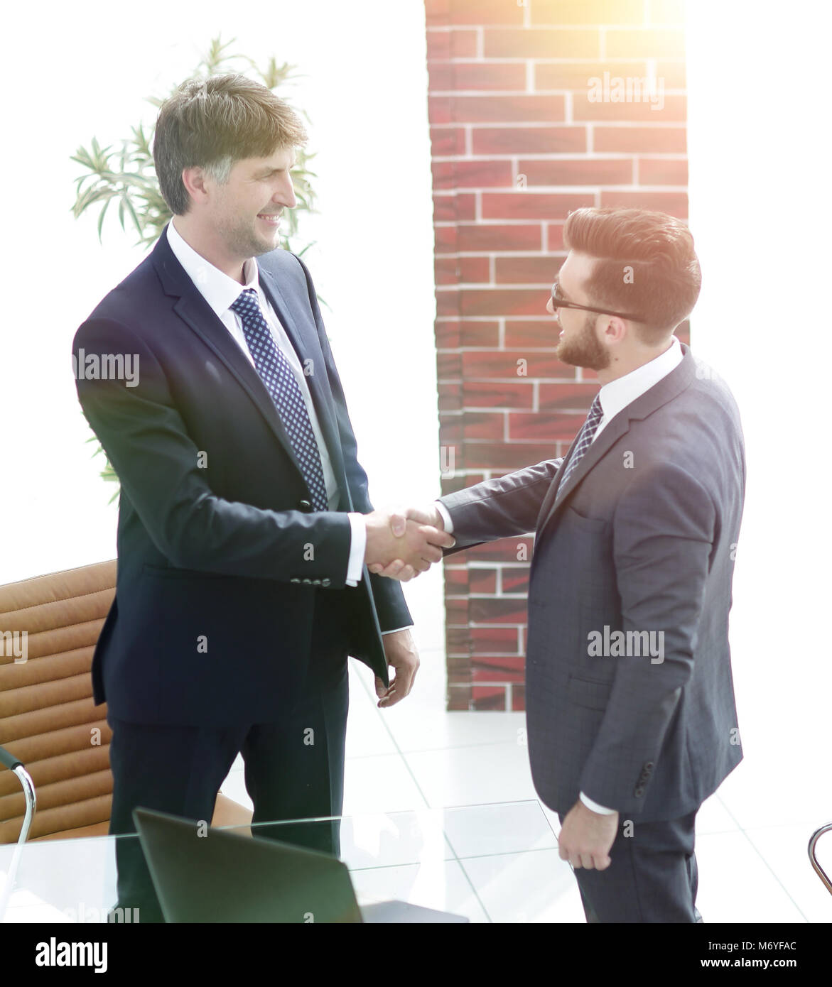 two businessmen shaking hands in office Stock Photo - Alamy