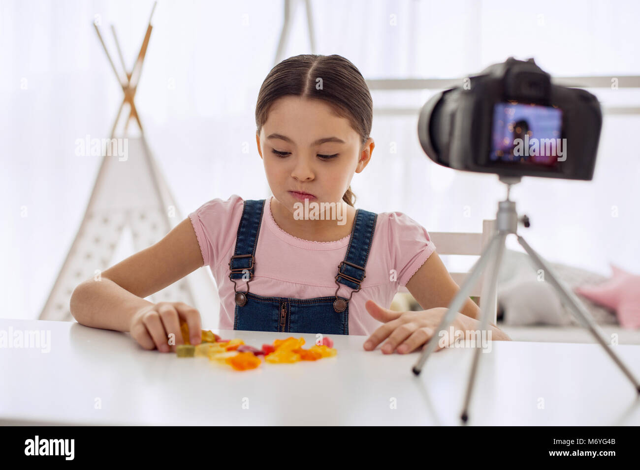 Cute girl eating gummy bears on camera Stock Photo