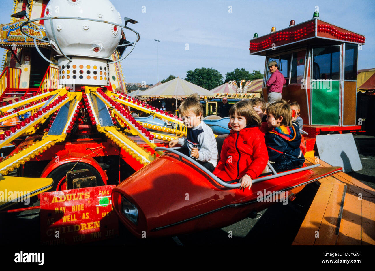 Young children on a kiddies ride at Nottingham Goose Fair, an annual travelling funfair held at the Forest Recreation Ground in Nottingham, England, during the first week of October. Archival photograph made in October 1987, England Stock Photo