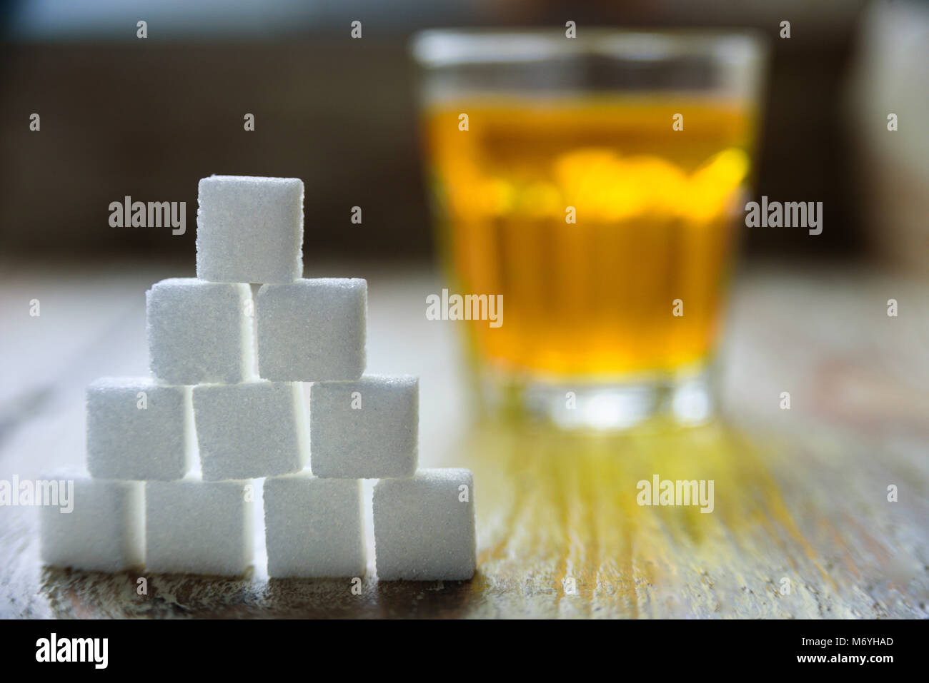 Sugar cubes with apple juice on background. Sugar danger concept Stock Photo