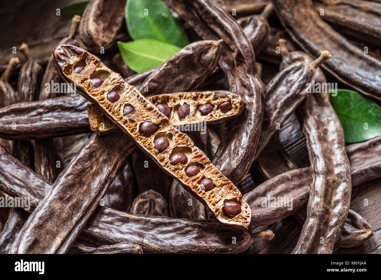 Carob pods and carob beans on the wooden table Stock Photo Alamy