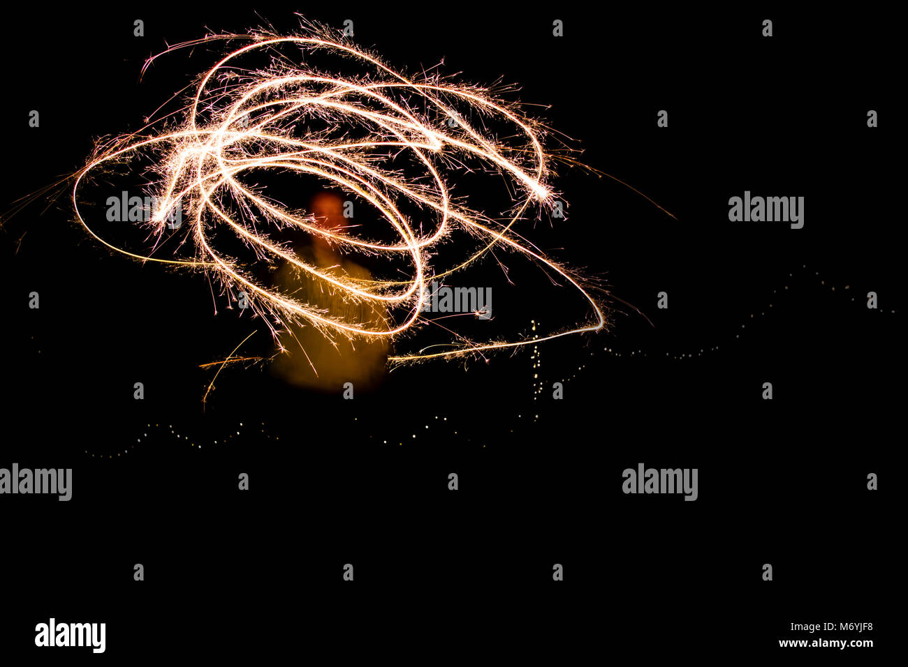 A young woman playing with sparklers at night. Stock Photo