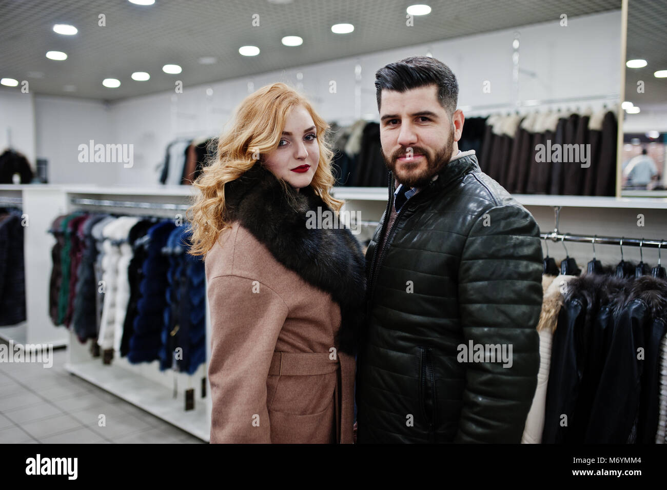 Elegance blonde girl in fur coat and stylish turkish man at the store of  fur coats and leather jackets Stock Photo - Alamy