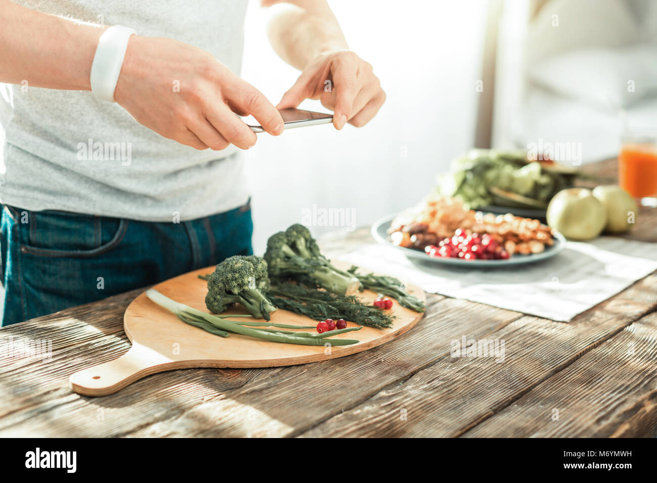 Skilful smart man making photo and cooking. Stock Photo
