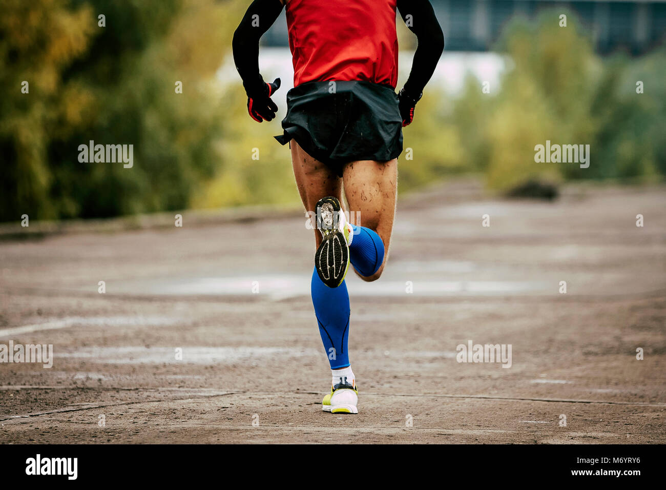 back man in compression calf sleeves and sportswear running on road Stock Photo