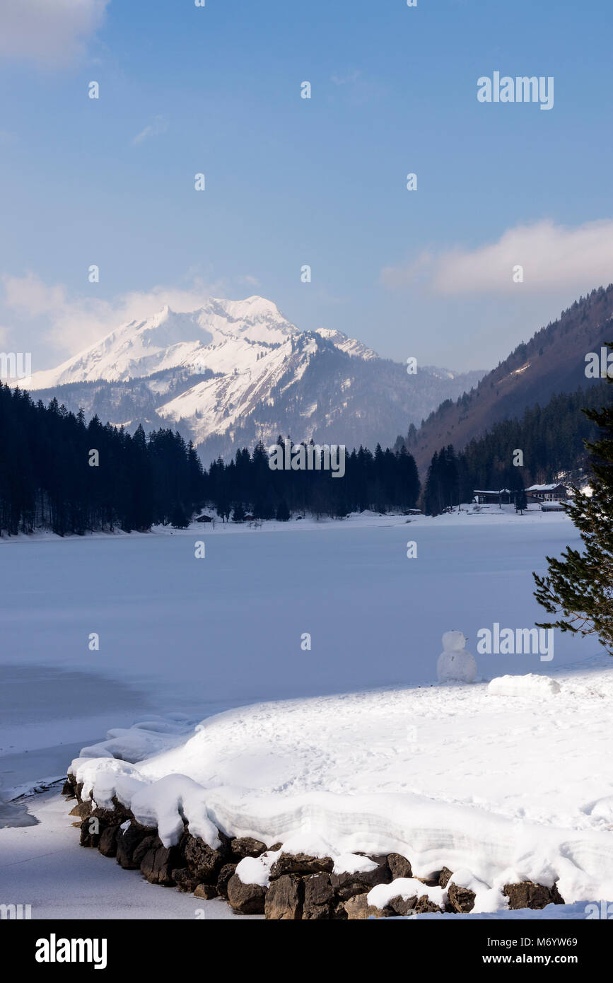 The Beautiful Frozen Lac de Montriond with Snow Covered Roc D'Enfer Mountain from Ardent Haute Savoie Portes du Soleil France Stock Photo