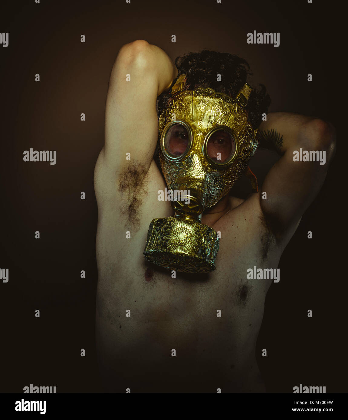 Safety, Man with gold gas mask and arabesques in poses of drowning and  desperation, depression and psychiatry concept Stock Photo - Alamy