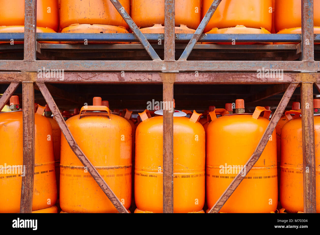 Used gas butane cylinder containers in orange tone. Horizontal Stock Photo