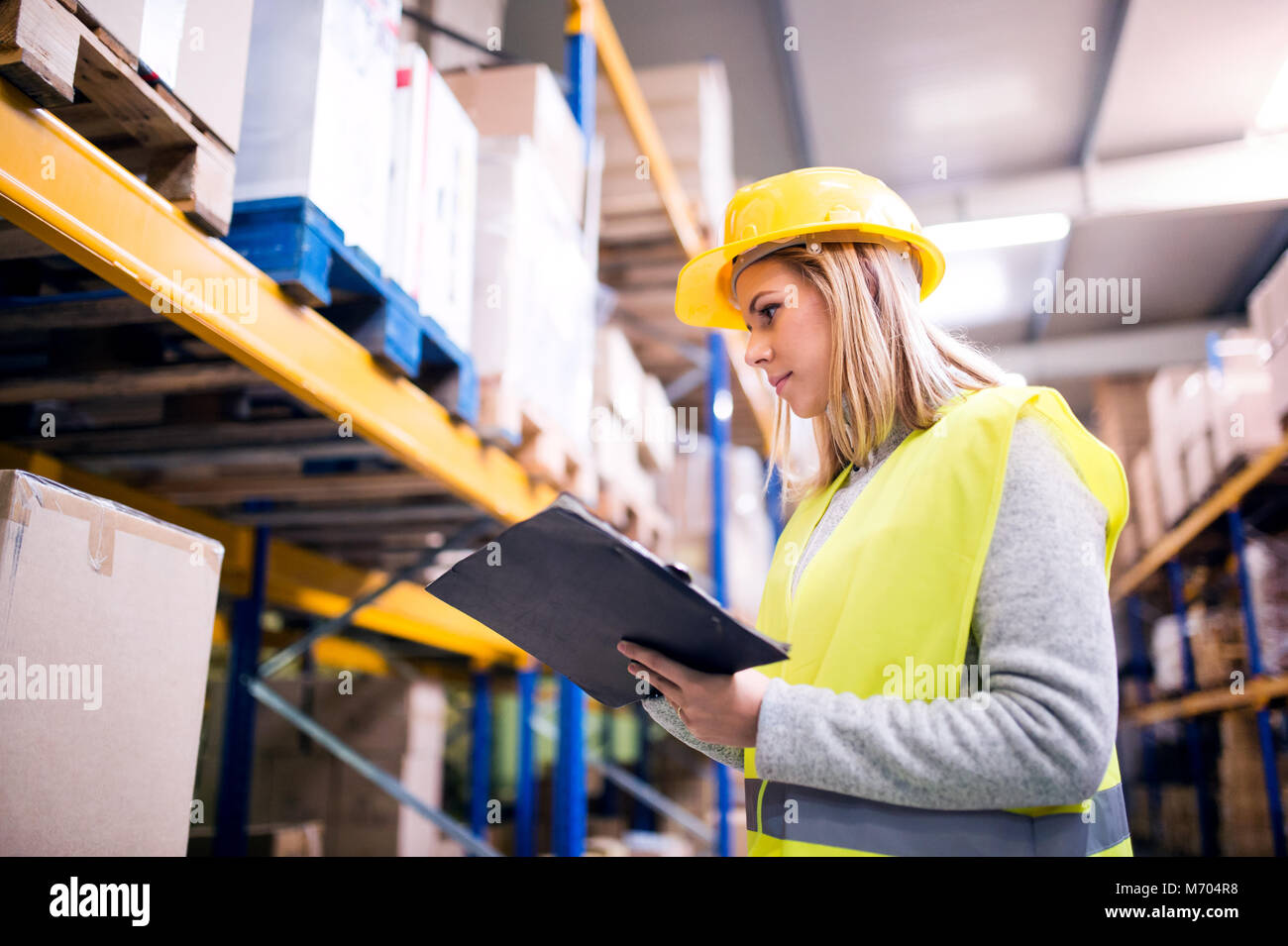Woman warehouse worker with clipboard. Stock Photo