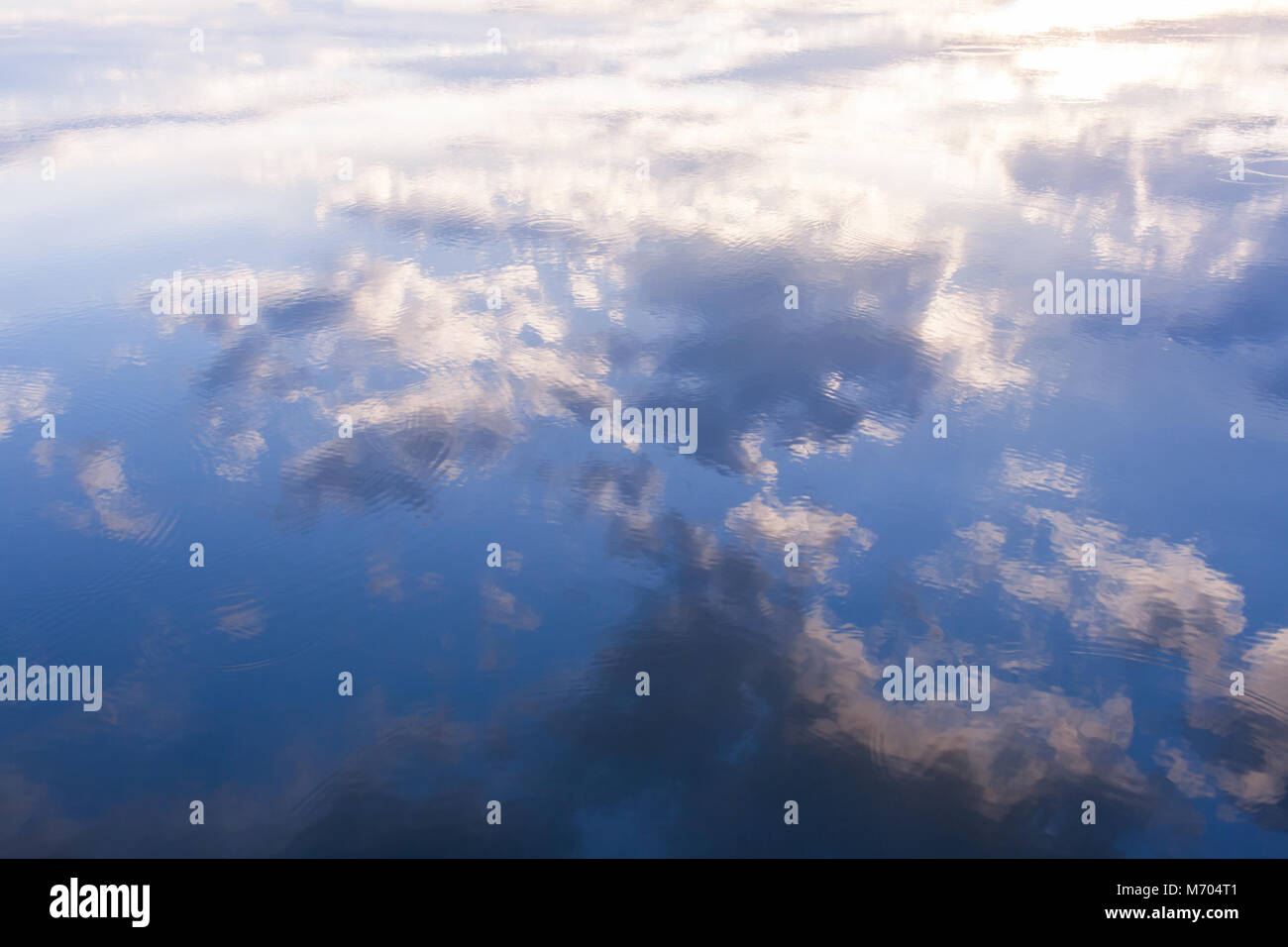Reflection of blue sky and white clouds in water Stock Photo - Alamy