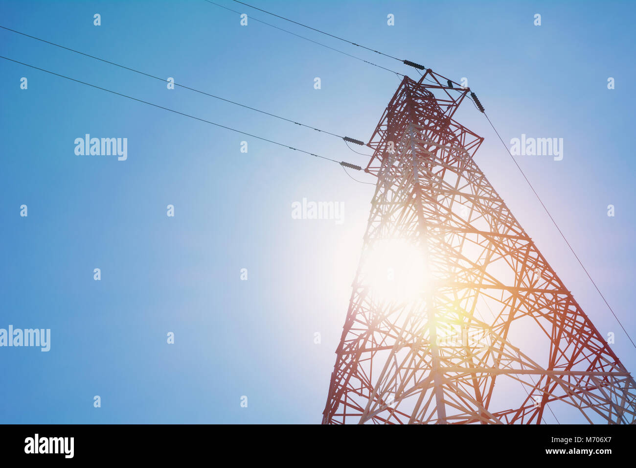 High voltage pole on blue sky background. High voltage tower. Stock Photo