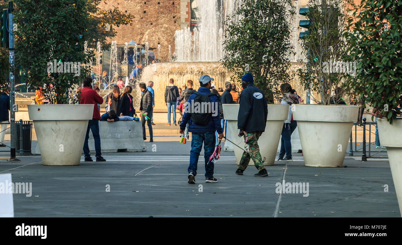 Milan, Italy - November 03, 2017:  street vendors sell selfie poles to tourists in front of the Castle of Sforza on a fall day Stock Photo