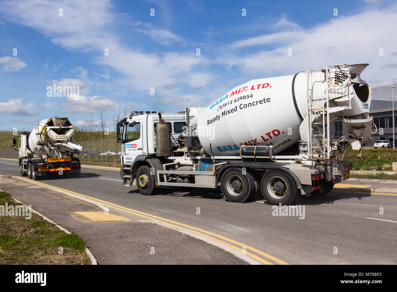 Two Baramix concrete mixing trucks, aka concrete lorry, leaving a construction site at Logistics North business and distribution park. Stock Photo