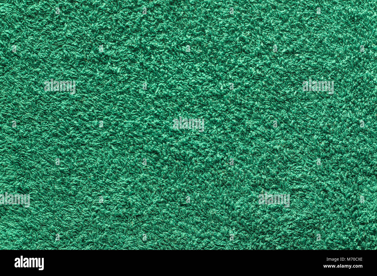 Abstract background of shaggy green carpet pile. Cloth texture with