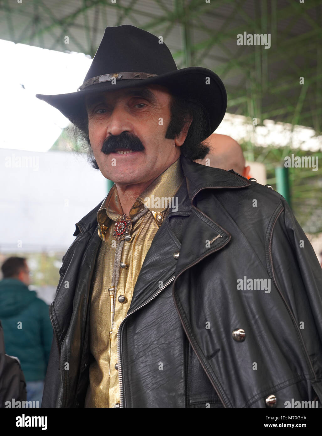 Dark man with a mustache in leather jacket in cowboy hat Stock Photo
