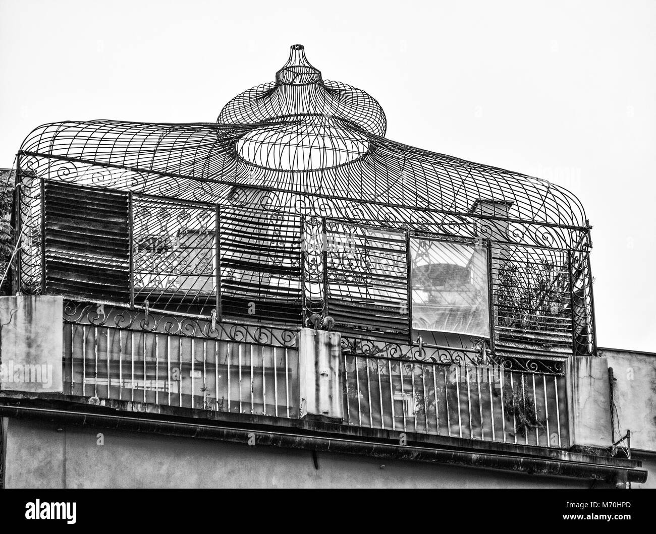 Old iron greenhouse on a terrace of a building Stock Photo