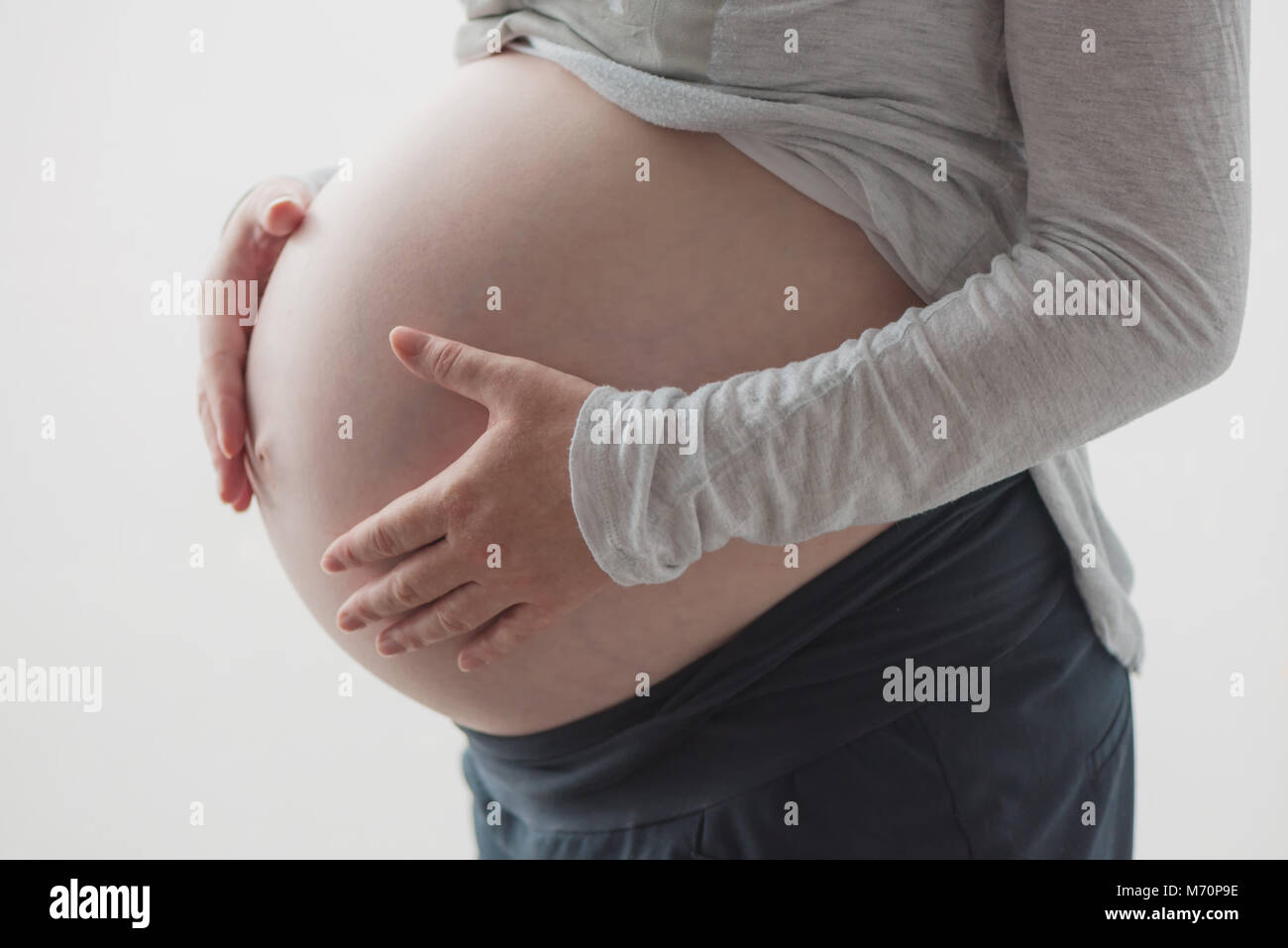 Pregnant woman tummy, female person in ninth month of pregnancy posing Stock Photo