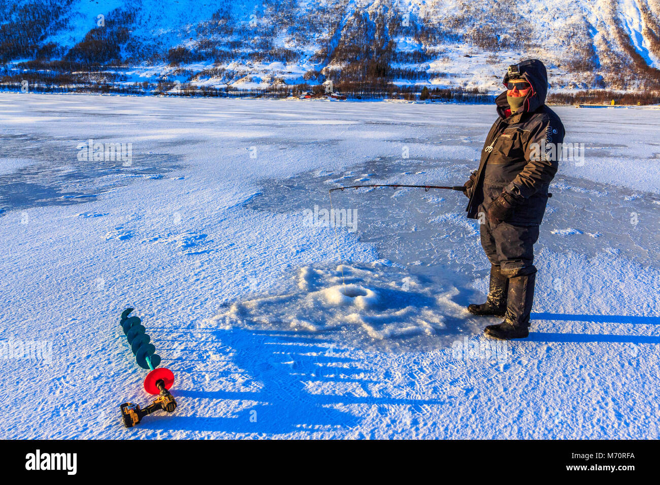 ice fishing frozen fjord ,Arctic Circle Kvaloya island Troms Tromso