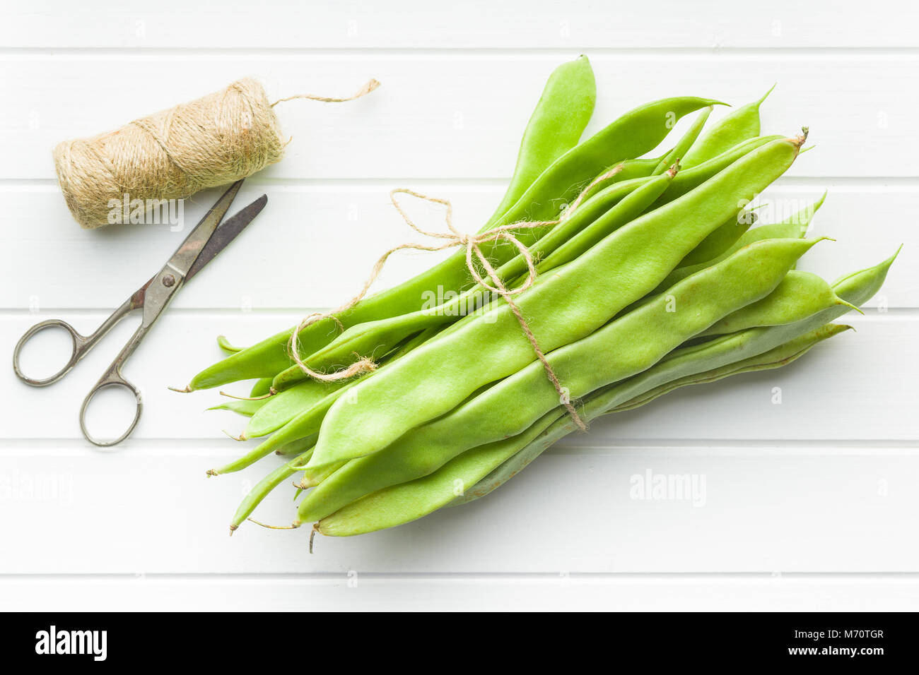 Green string beans pods on white table. Stock Photo