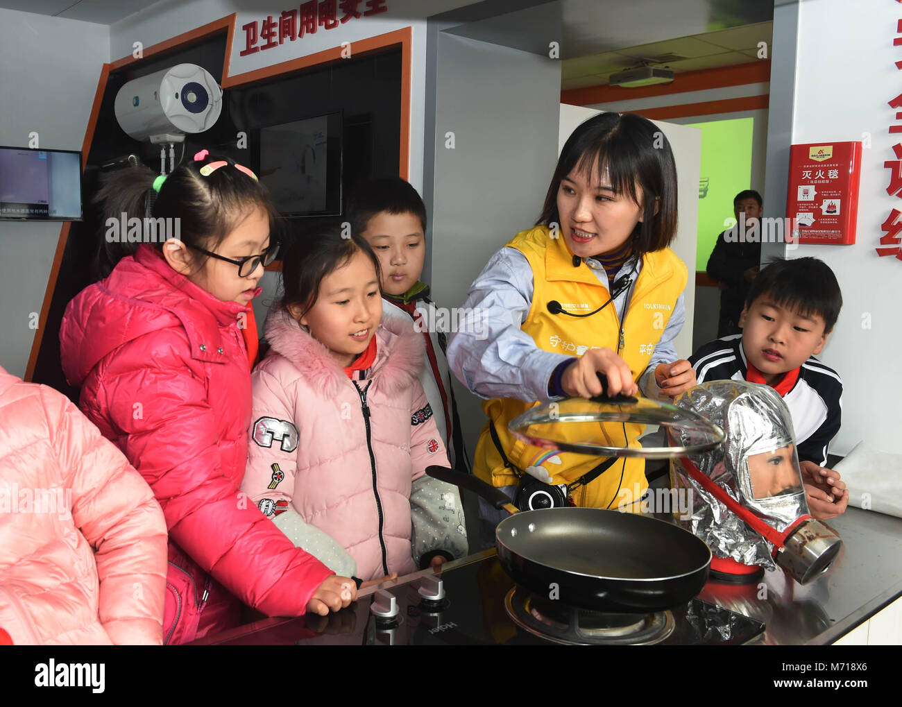 Qingdao, China's Shandong Province. 7th Mar, 2018. An instructor explains kitchen fire emergency measures to children at a home safety training center in Qingdao, east China's Shandong Province, March 7, 2018. The Qingdao Municipal Women's Federation organized a home safety workshop on Wednesday, allowing participants to learn home safety knowledge and skills via on-the-spot training sessions. Credit: Li Ziheng/Xinhua/Alamy Live News Stock Photo