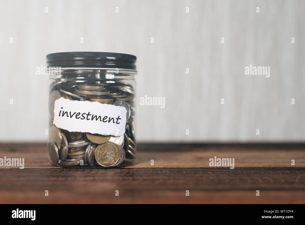 coins in a jar with label written INVESTMENT. financial concept Stock Photo