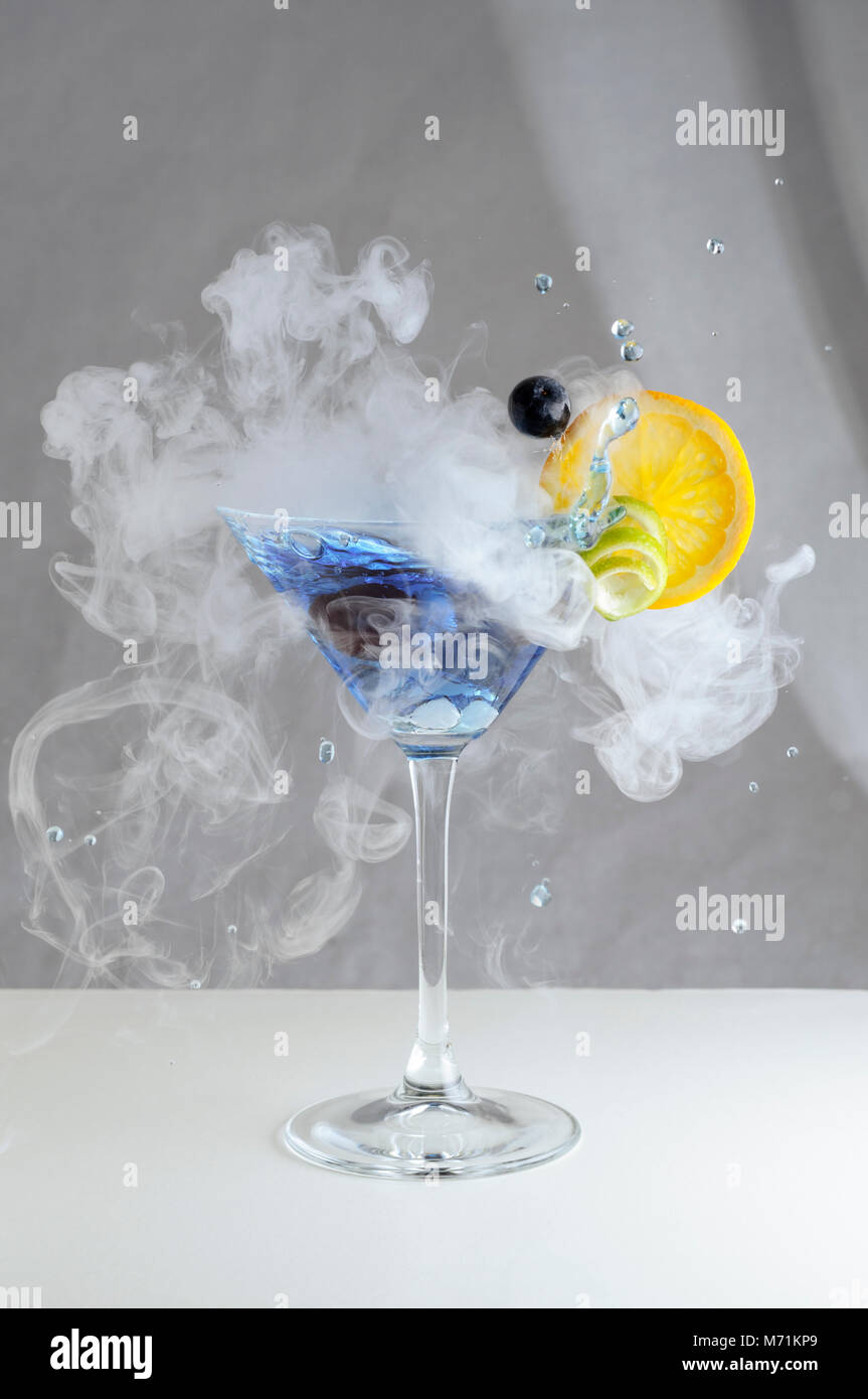 Elegant smoking craft cocktail with fruit in a martini glass Stock Photo