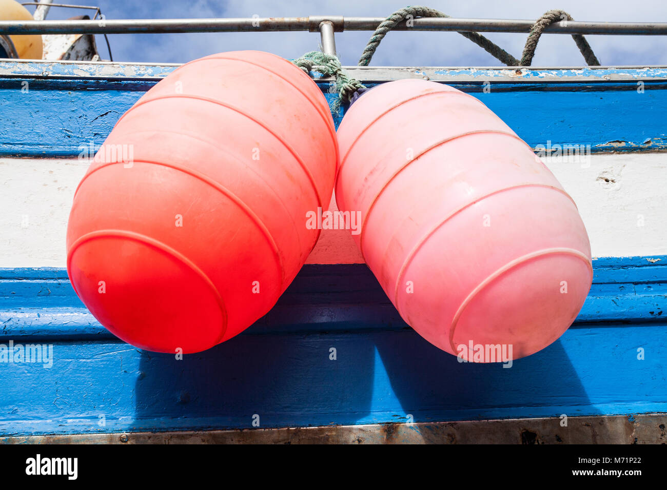 Two bright buoys hanging from the side of a fishing boat on the island of Lanzarote, Spain Stock Photo