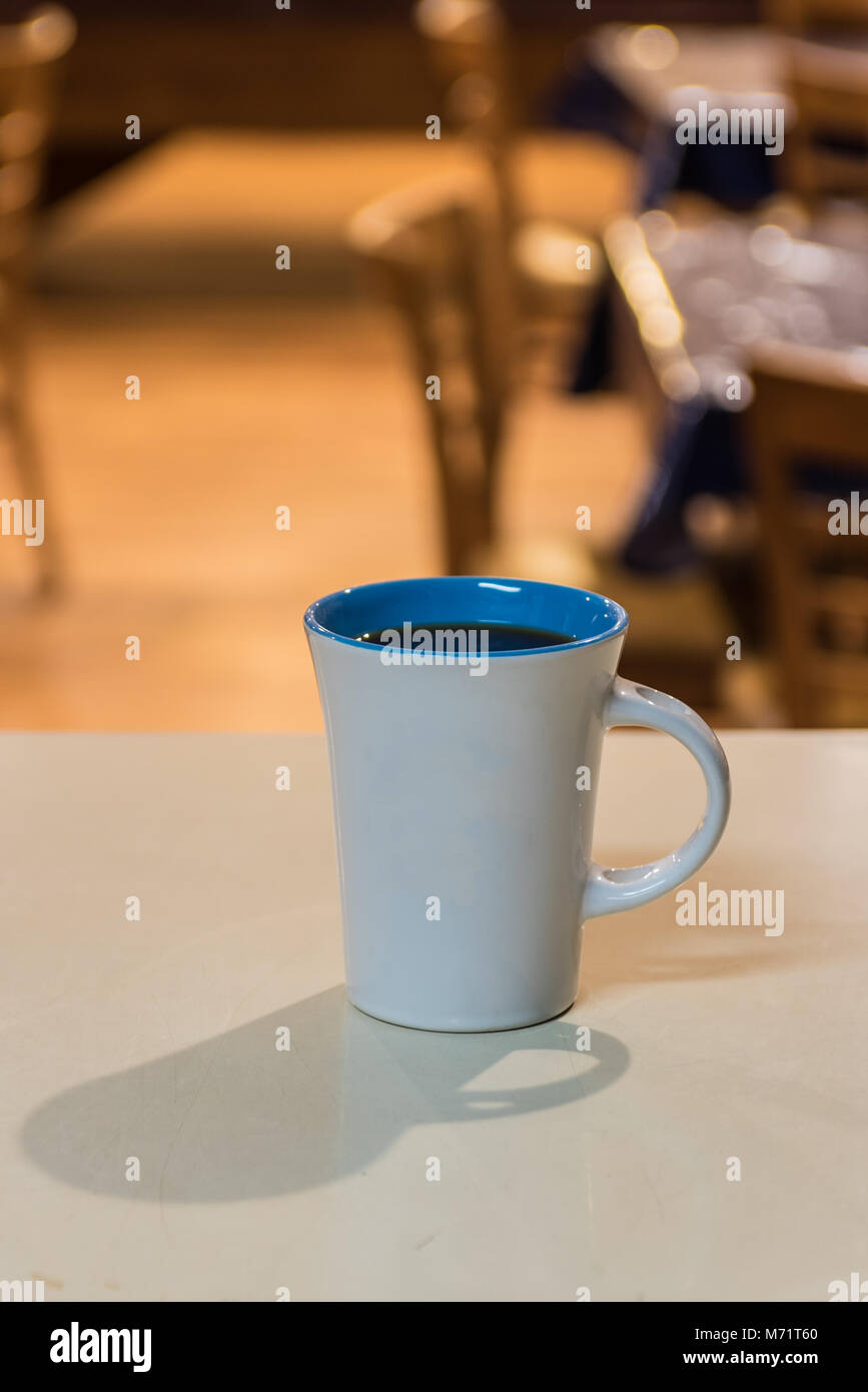 Cup of freshly brewed coffee on waiting on counter top at breakfast cafe. Stock Photo